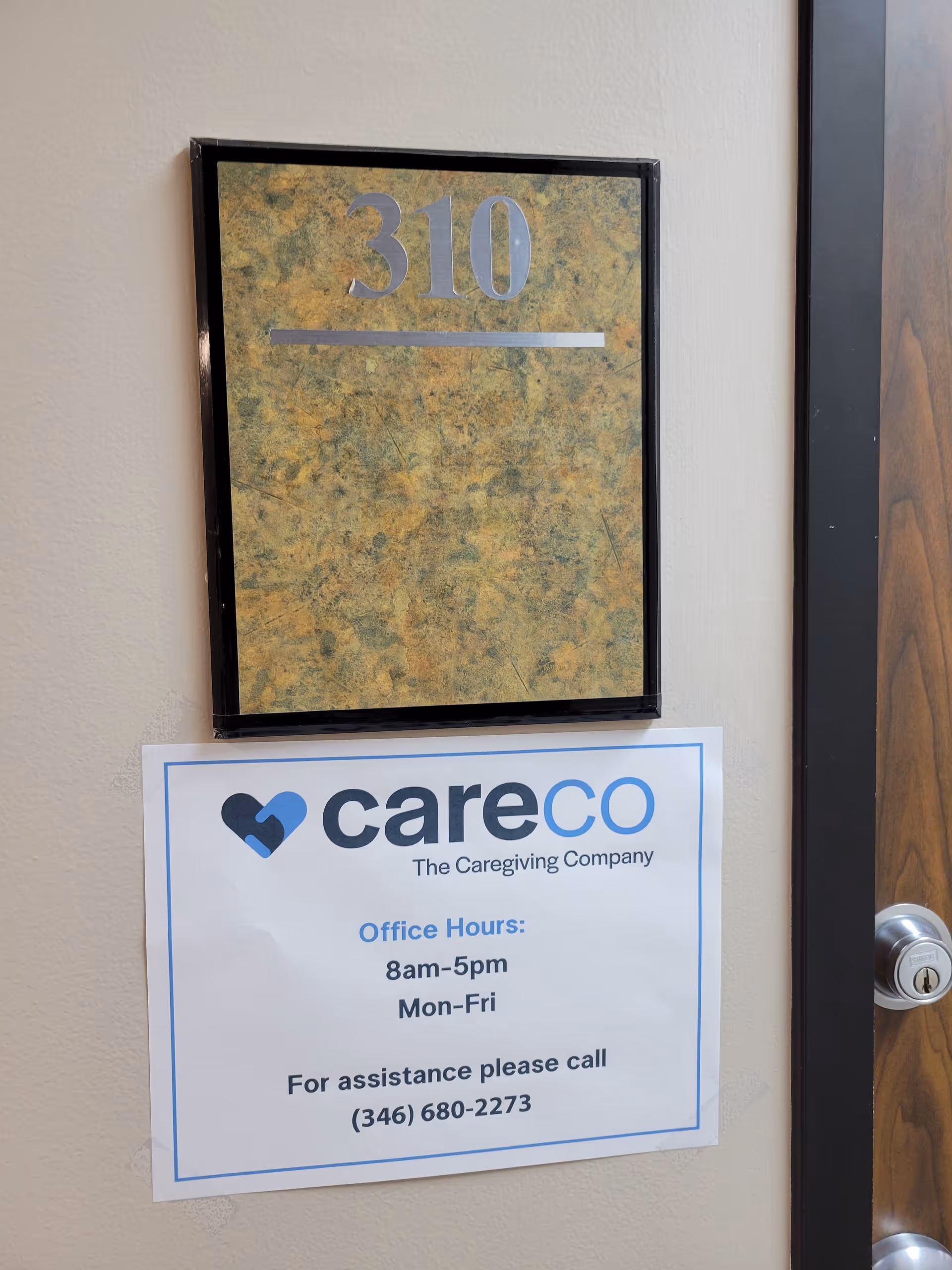 Interior hallway wall featuring a door plaque 310 and a CareCo hours sign.