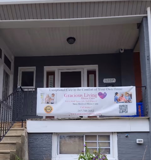 Exterior of Gracious Living Home Care facility with a banner on the front balcony.