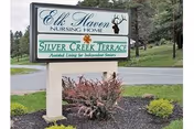 Outdoor sign for Elk Haven Nursing Home with landscaped shrubs along the road.
