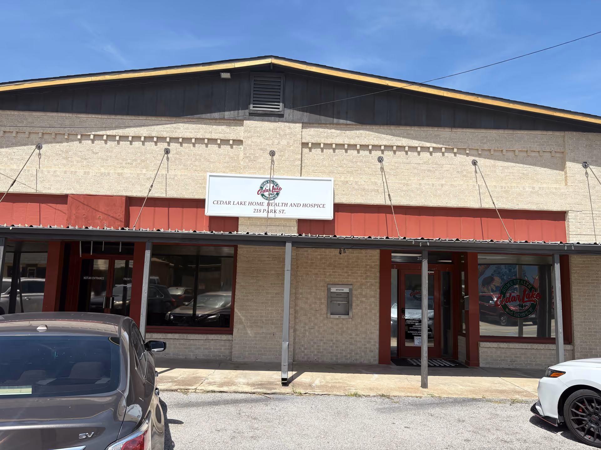 Front exterior of Cedar Lake Home Health & Hospice, storefront entrance and parked cars.