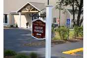 Exterior view of Welles Country Village entrance with a visitor parking sign.