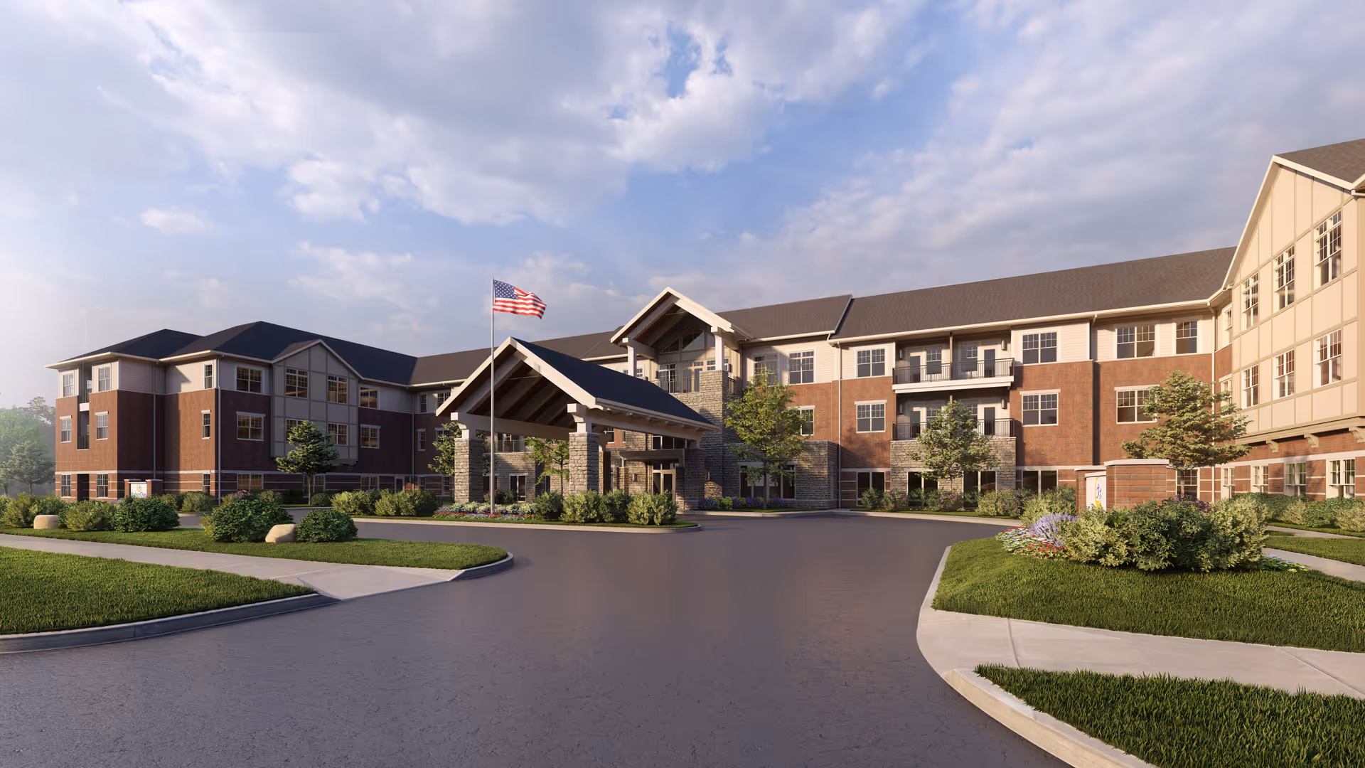Front exterior of a three-story senior living facility with a covered entrance, American flag, and landscaped driveway.