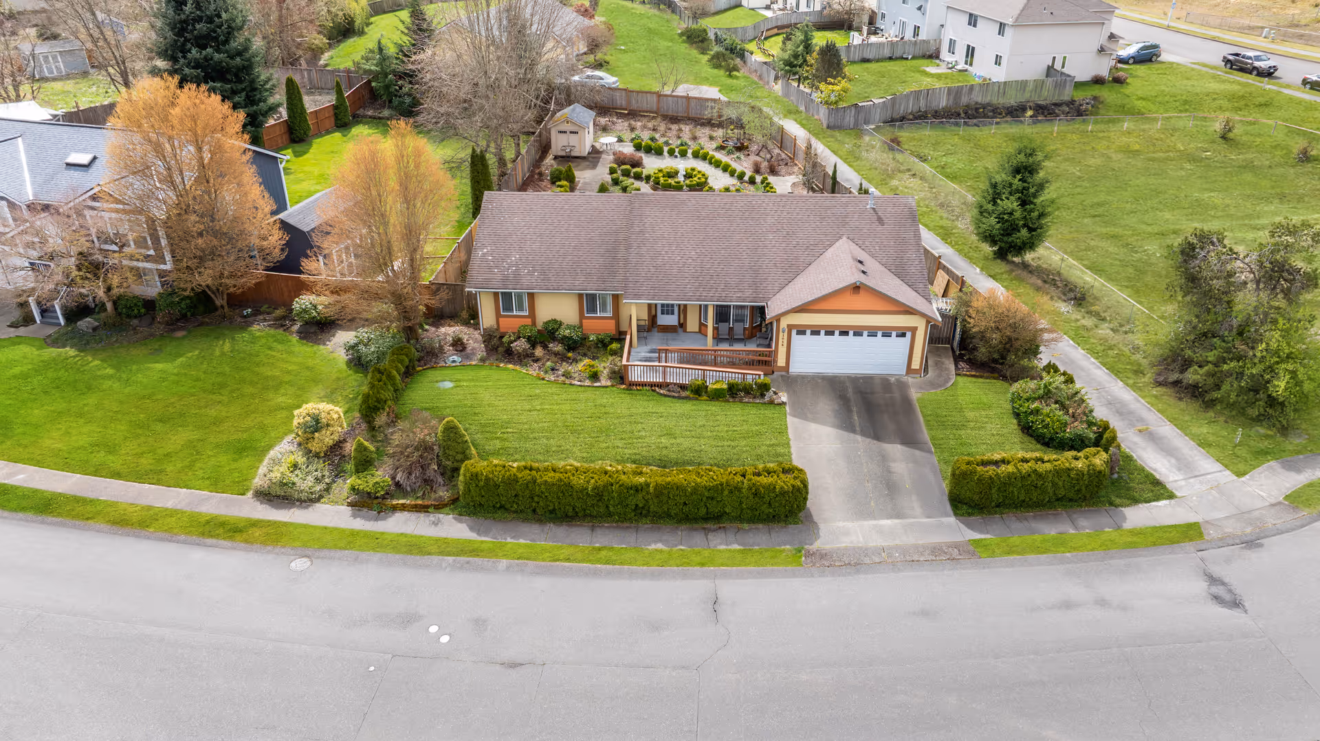 Aerial view of a single-family home with front yard and driveway along a street.