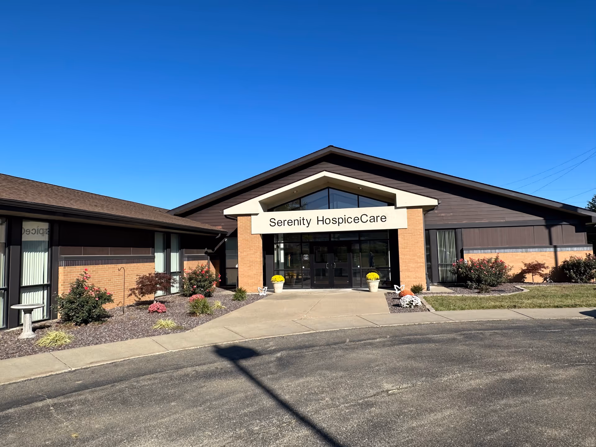 Front view of Serenity HospiceCare building with glass entrance and landscaping.