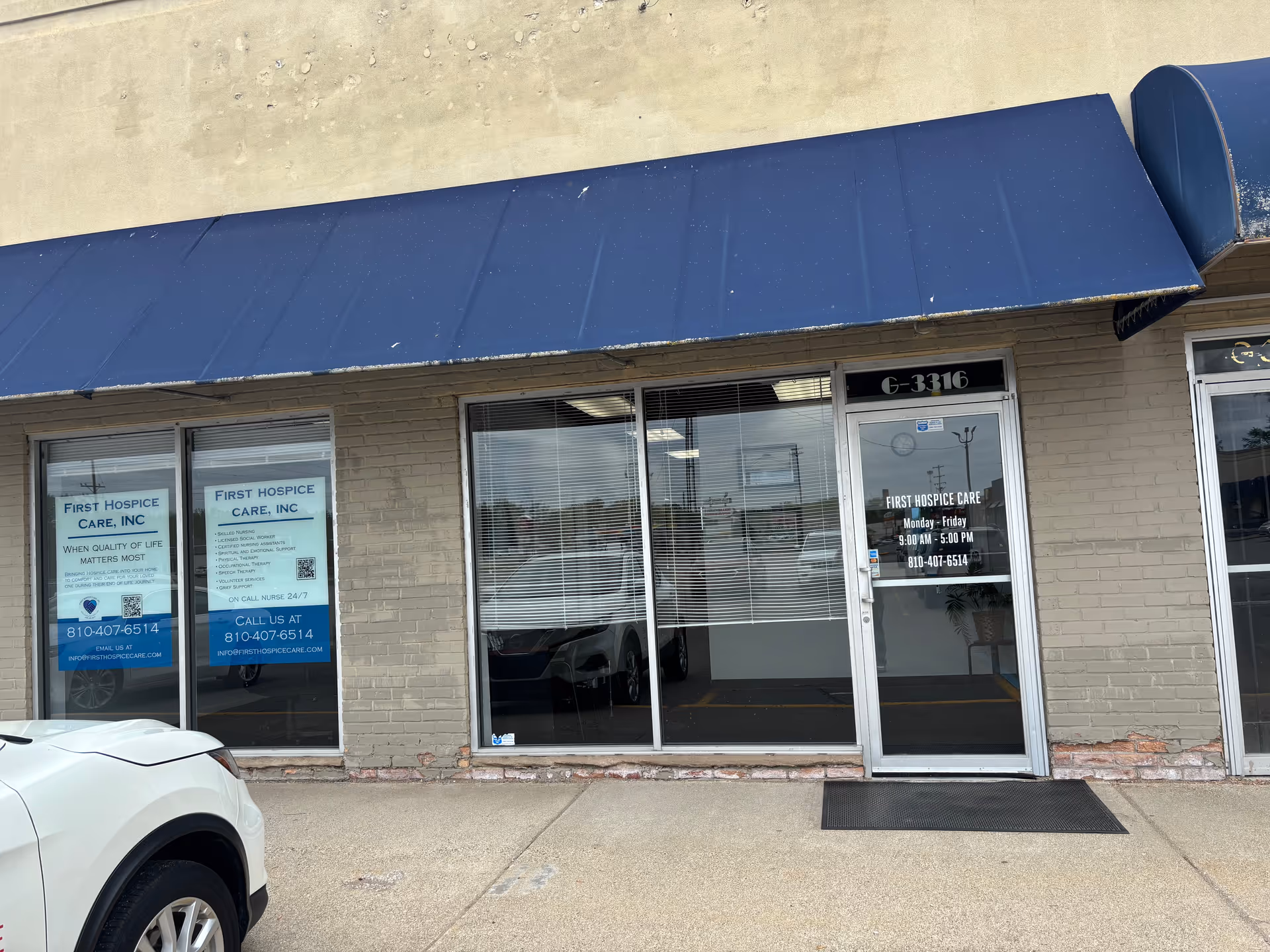 Exterior view of First Hospice Care, Inc. storefront with blue awning and glass doors.
