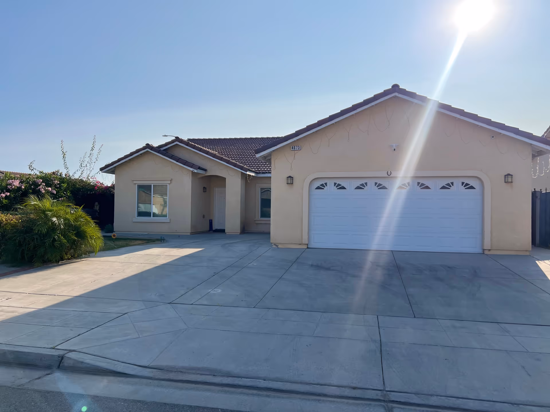 Residential-style single-story building with a two-car garage and wide concrete driveway.