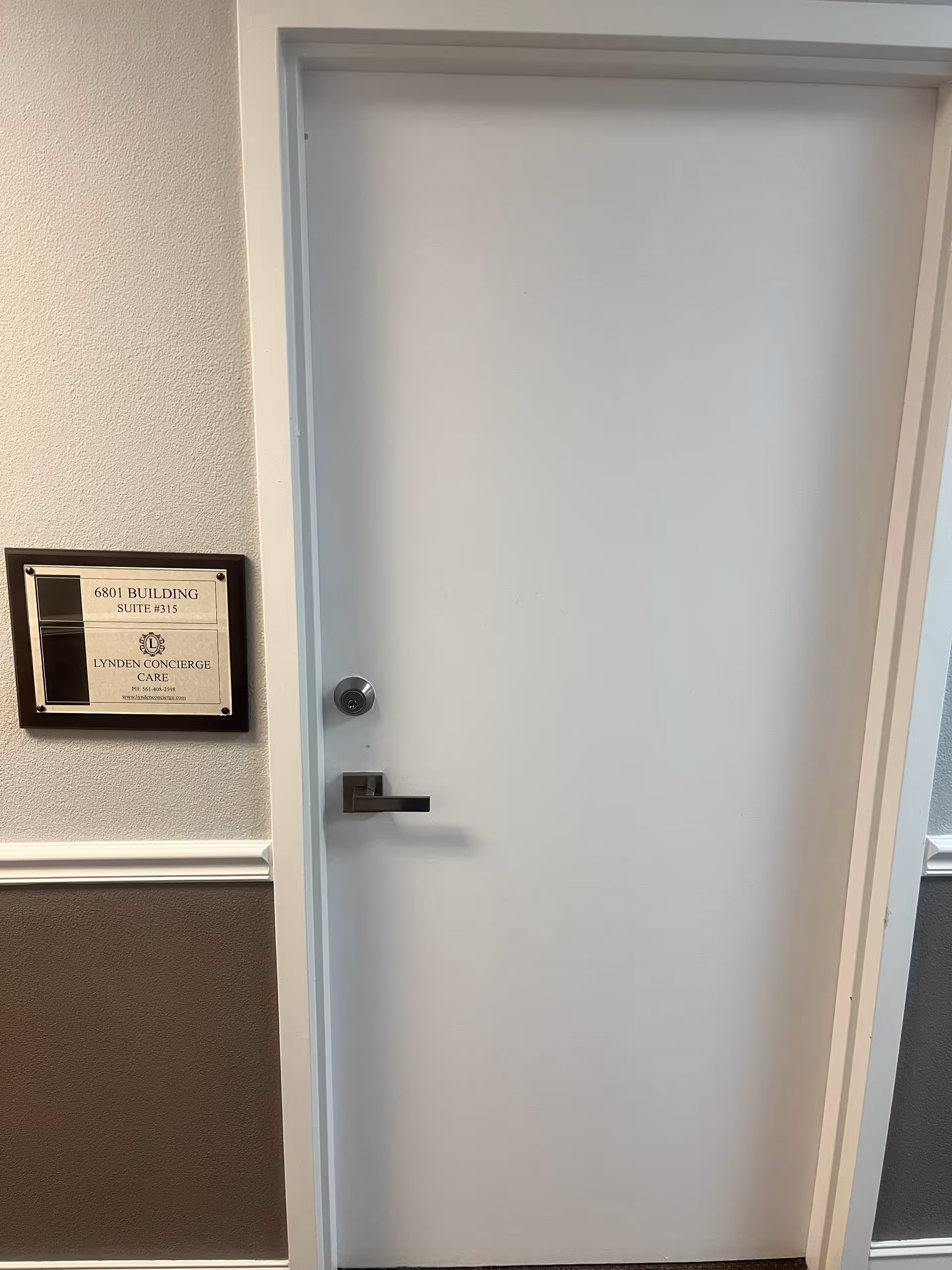 A white interior door sits in a hallway beside Lynden Concierge Care plaque.