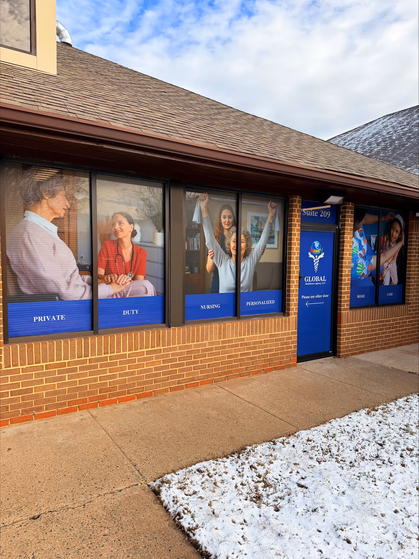 Brick building exterior with window banners advertising private duty nursing and Suite 209