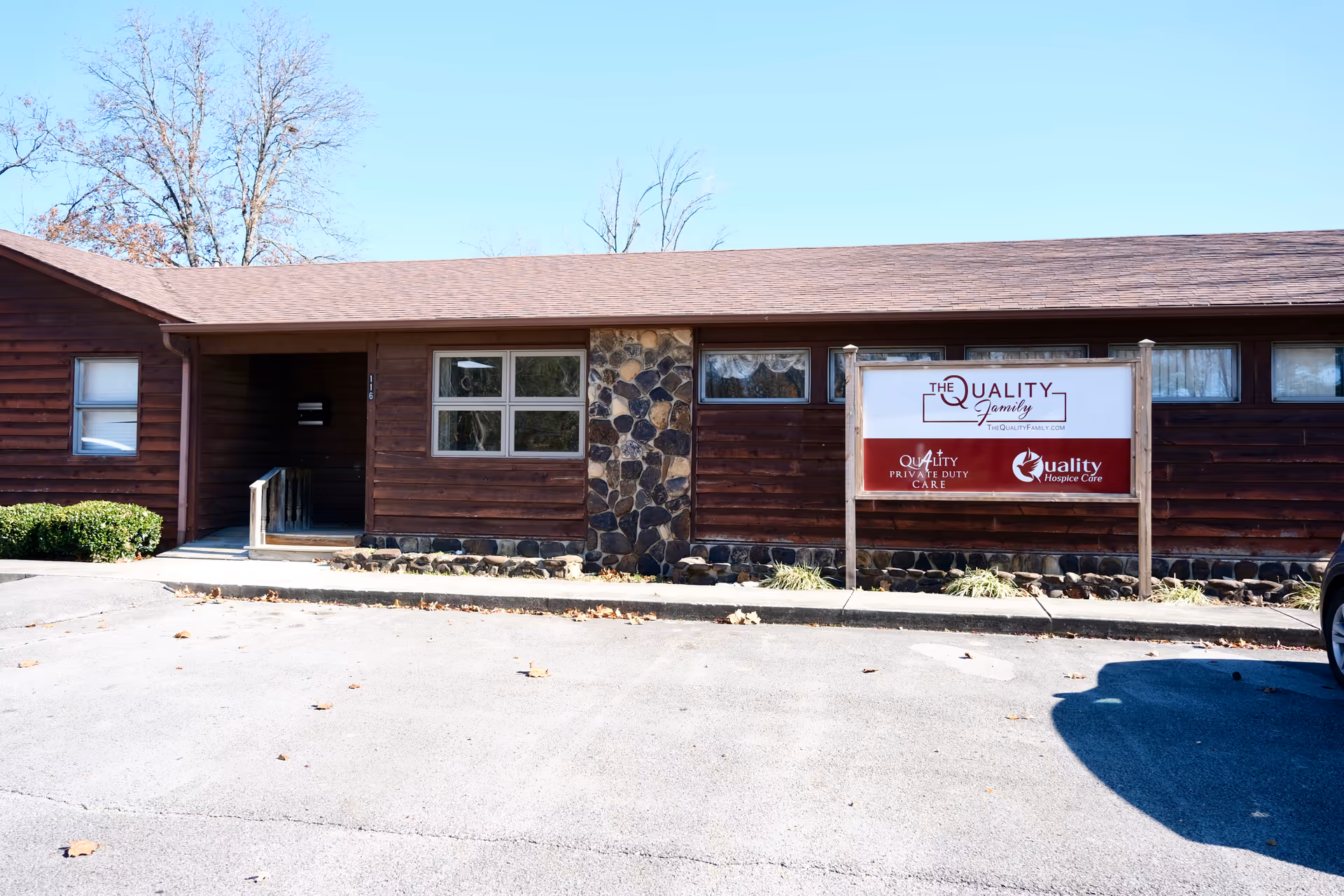 Front view of a brown wooden senior care building with a Quality Private Duty Care sign.