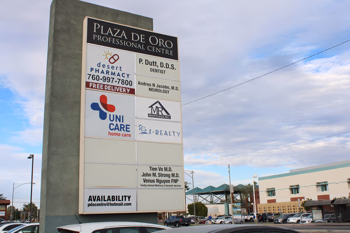 Tall outdoor signboard advertising Uni Care Home Care among other businesses in a parking lot.