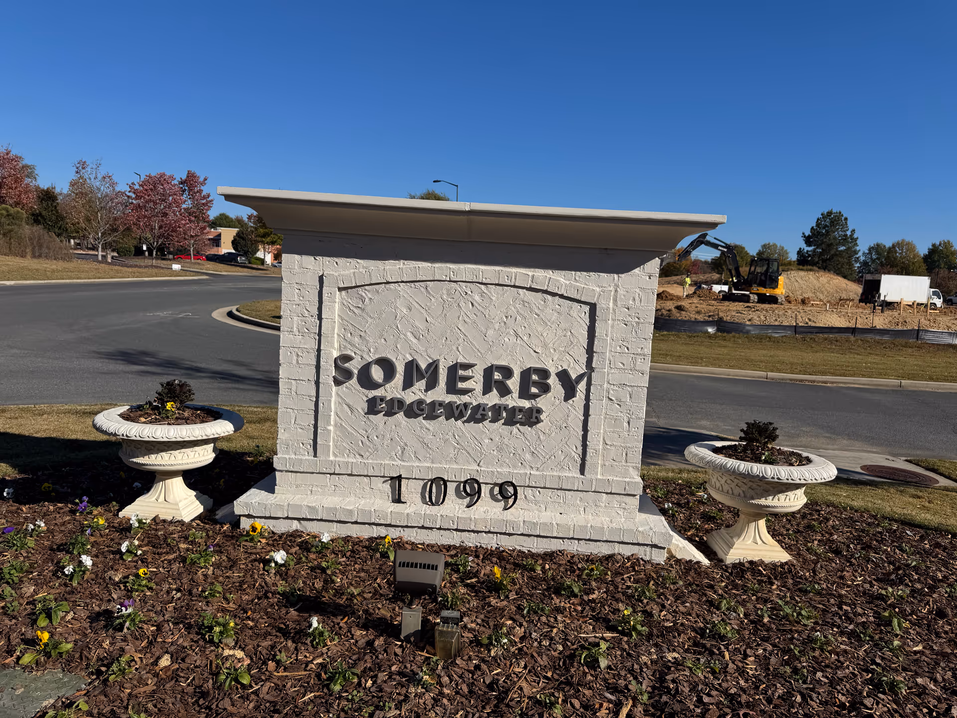 Stone entrance sign reading Somerby Edgewater, with landscaping and road nearby.