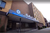 Exterior view of Bedford Center for Nursing and Rehabilitation entrance under blue awning