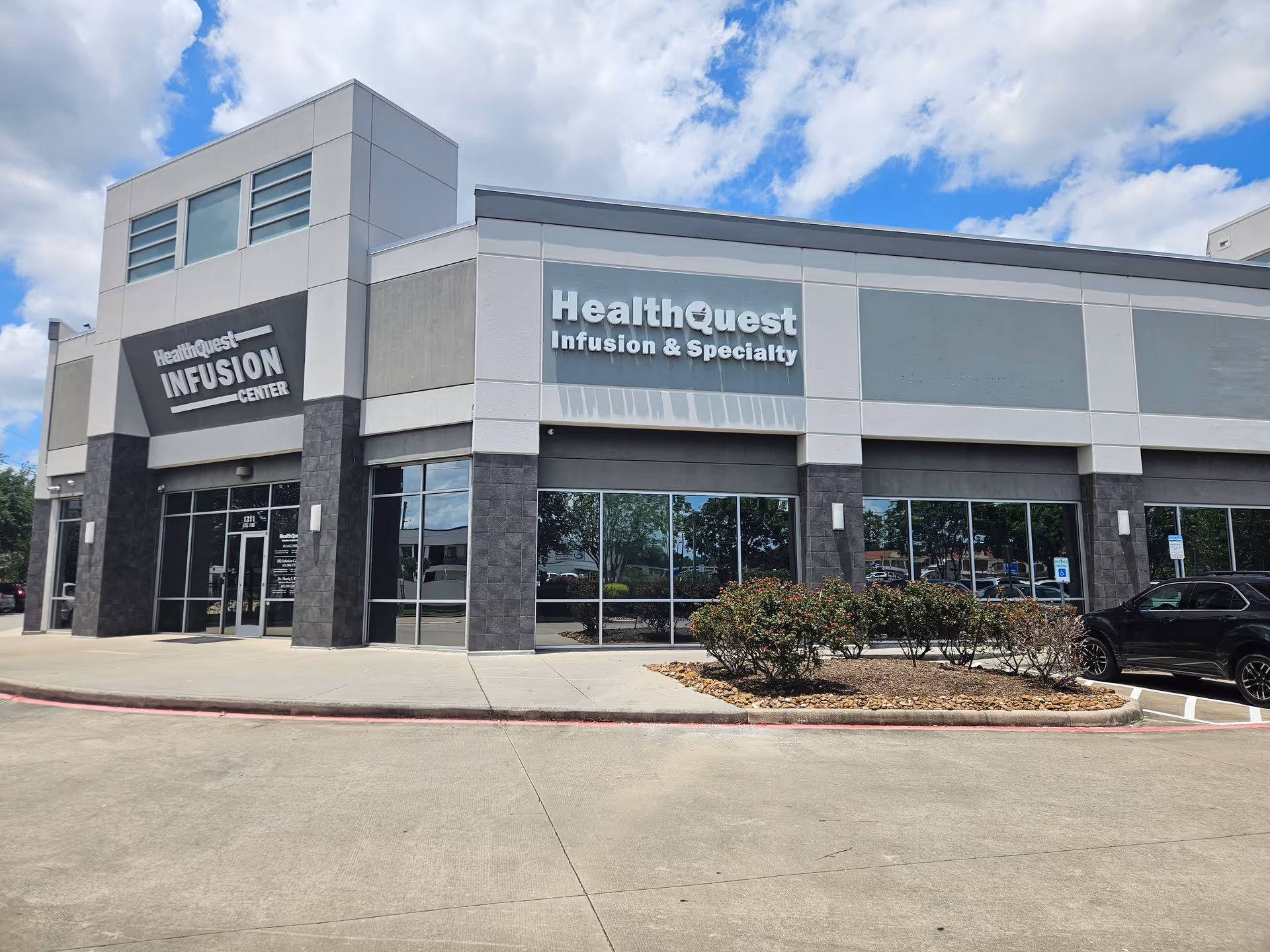 Exterior view of HealthQuest Infusion & Specialty building with glass storefronts.