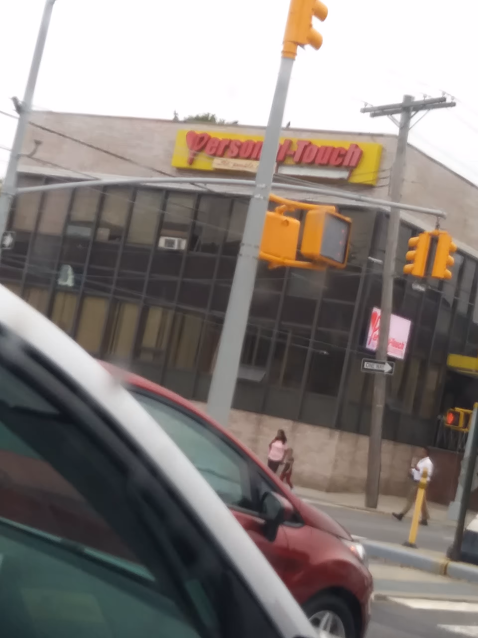 Street-front view of a building with Personal-Touch Home Care sign and traffic lights.