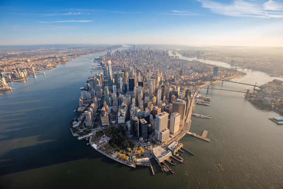 Aerial view of a dense city skyline surrounded by water and bridges