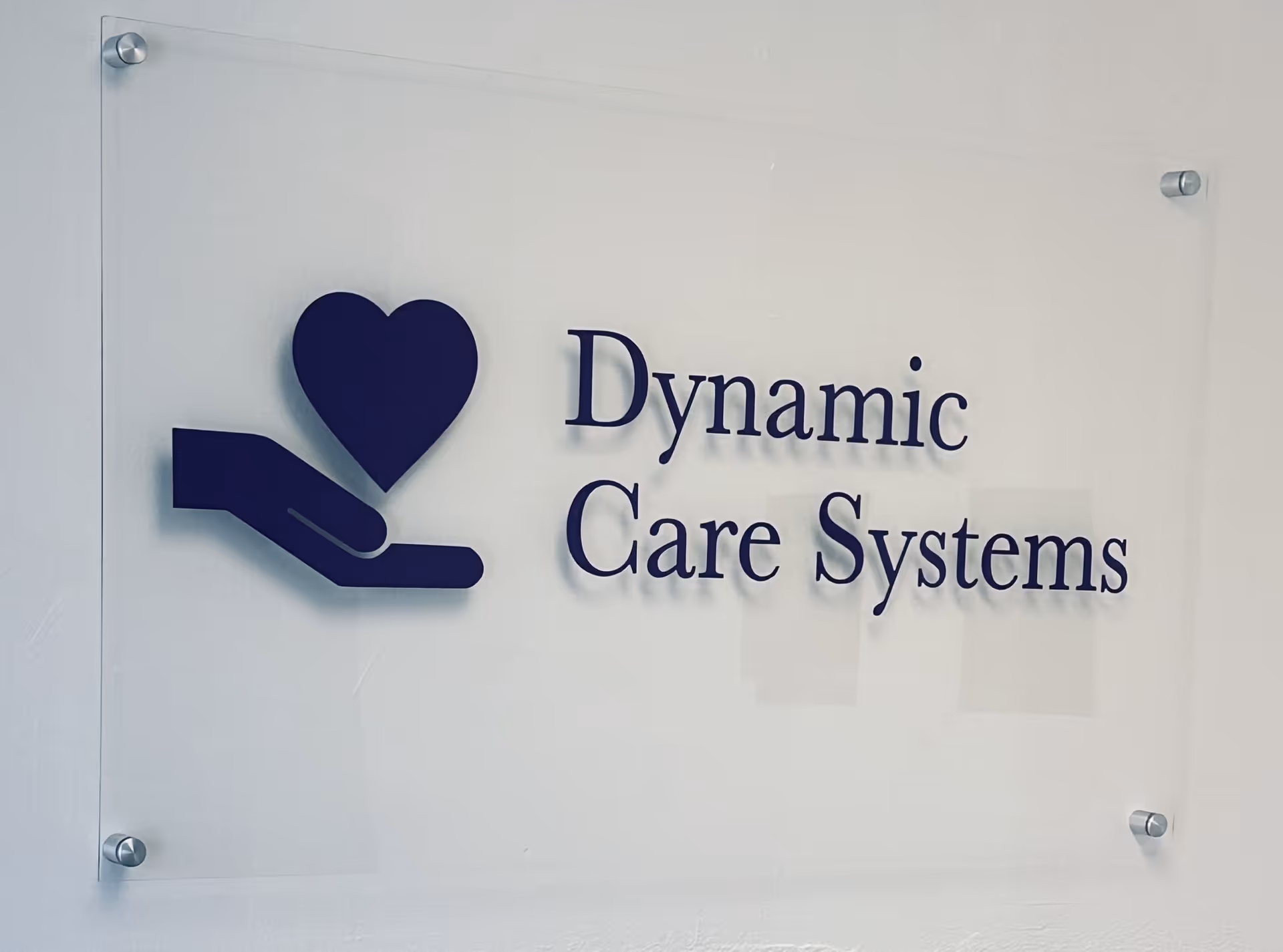 A wall-mounted sign reads Dynamic Care Systems with a heart-and-hand logo.