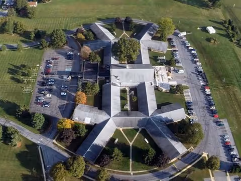 Aerial view of Lancashire Hall senior living facility with cross-shaped wings and parking.
