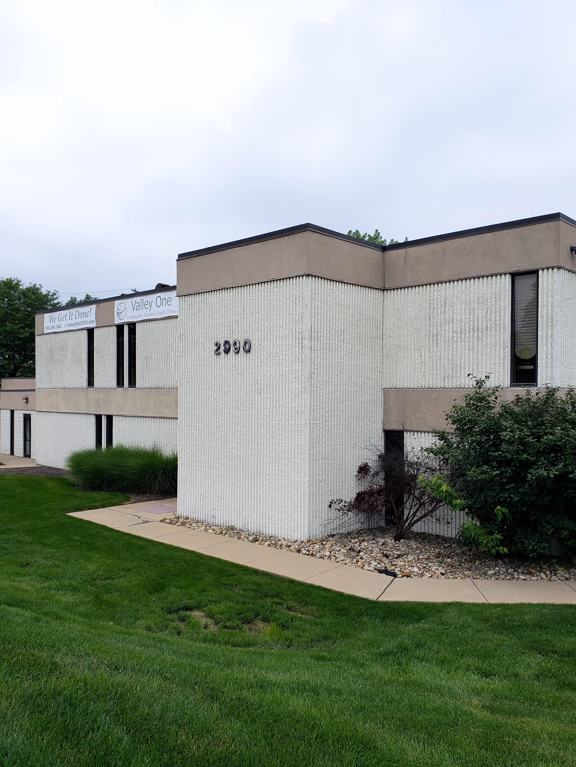 Exterior view of a Cambridge Caretenders senior living facility with landscaping.