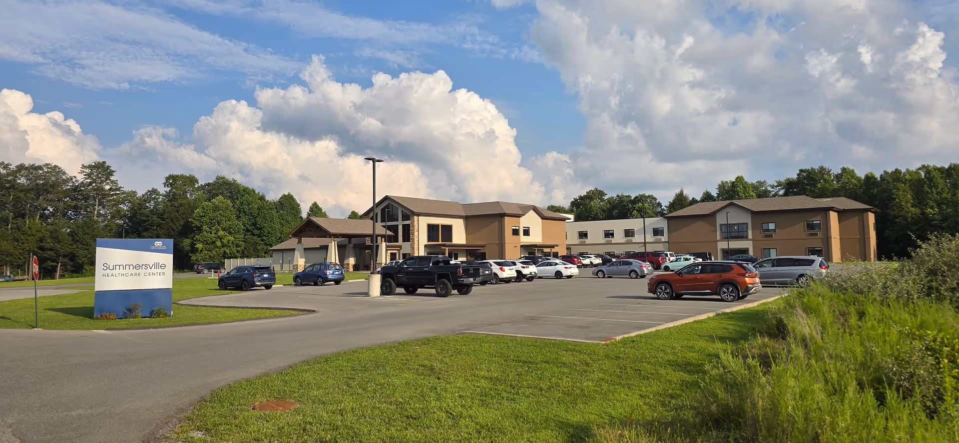 Exterior view of Summersville Healthcare Center with parking lot and sign.