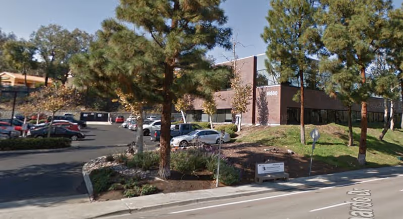 Exterior view of Active Health Services facility with parking, trees, and a brick building.
