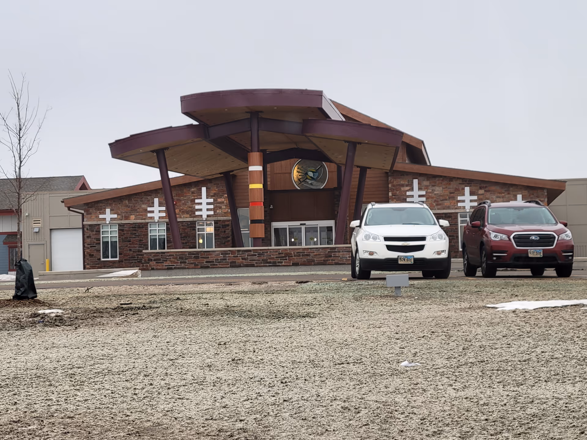 Front view of a brick care center with a distinctive purple-roofed entrance and parked cars.