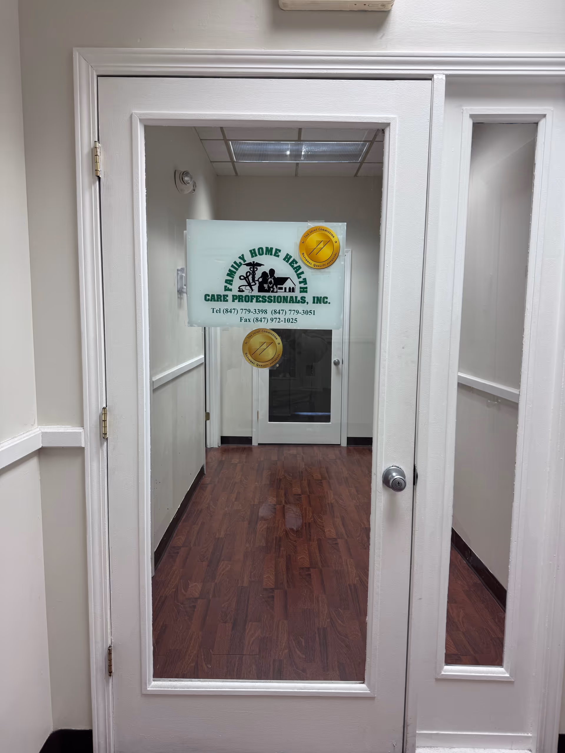 White hallway with a glass door bearing a sign for Family Home Health Care Professionals, Inc.