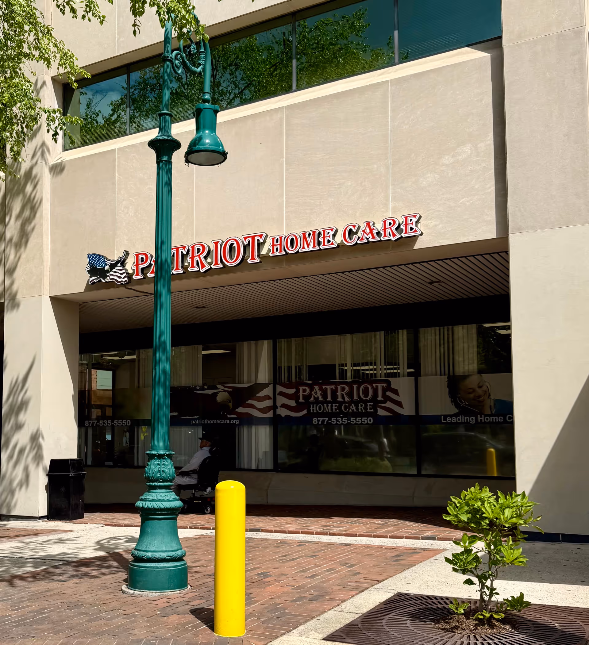 Exterior view of Patriot Home Care building front with signage and green lamppost.