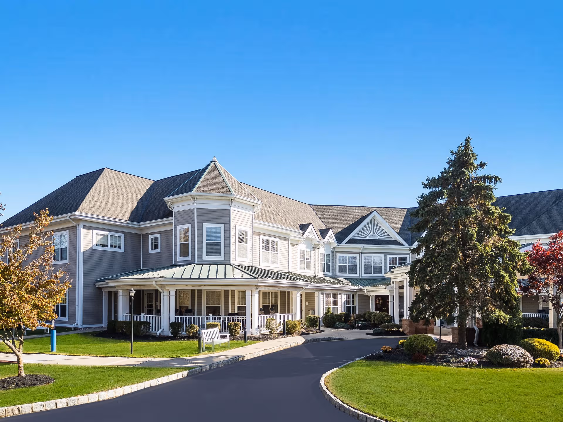 Front exterior view of Sunrise of East Brunswick assisted living building with landscaped entrance.