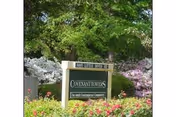 Covenant Towers sign at a landscaped exterior entrance with trees and flowering shrubs.