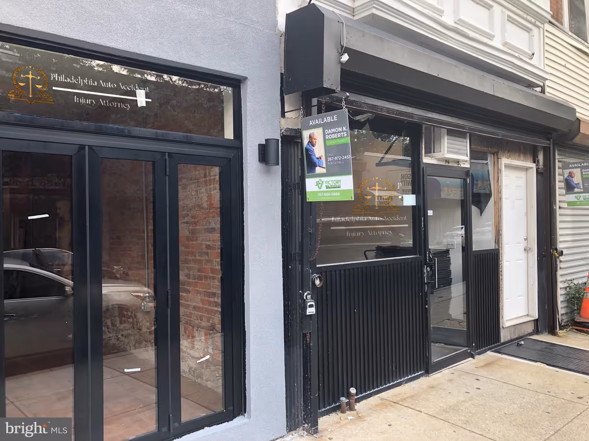 Exterior storefront with black-framed glass doors and attorney signs on windows.