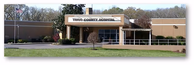Exterior view of Trigg County Hospital entrance with flagpole and landscaped lawn.