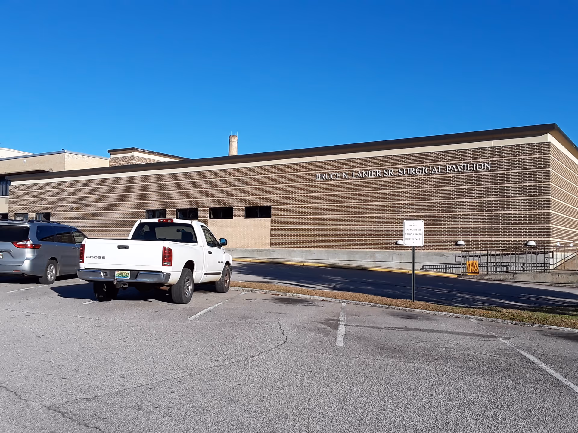 Exterior brick medical facility with parking lot and Bruce N. Lanier Sr Surgical Pavilion sign