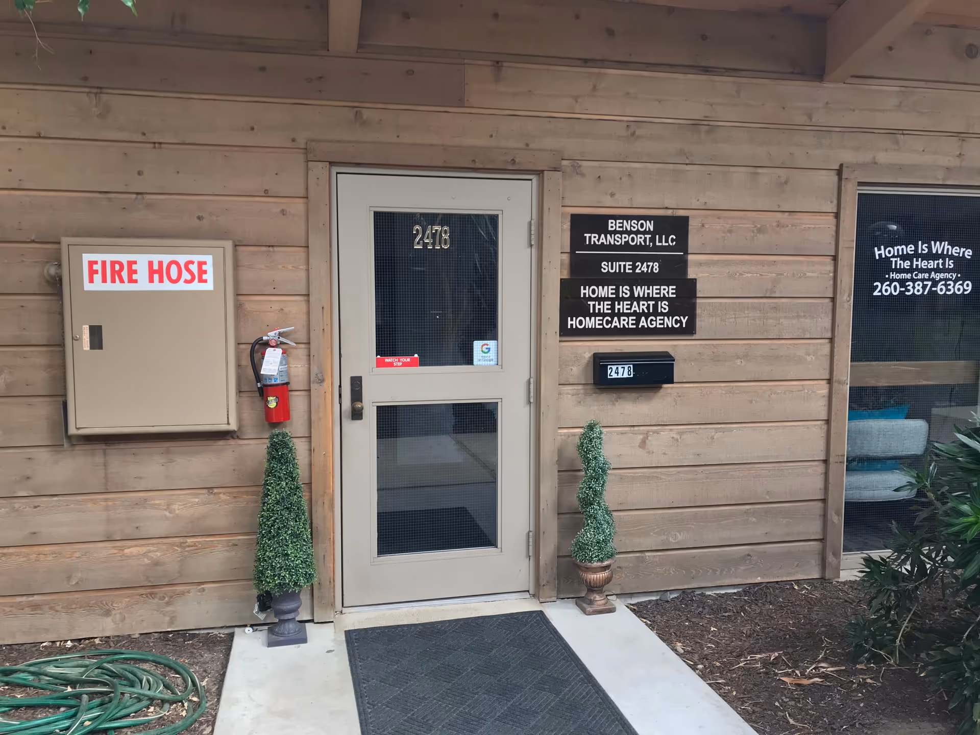 Exterior entrance of Home Is Where the Heart Is with signs and planters