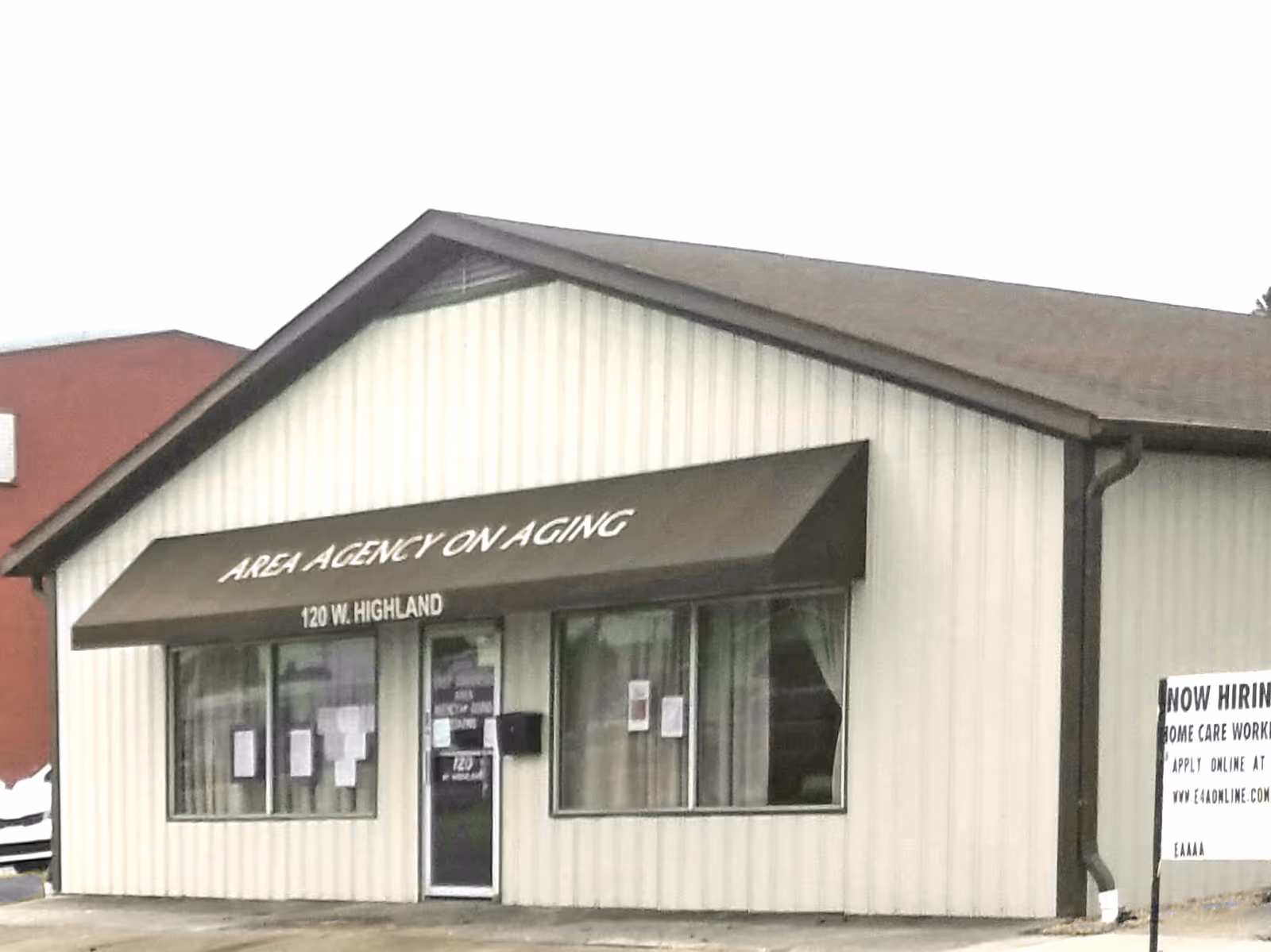 Front exterior of a small building labeled Area Agency on Aging with windows and door.