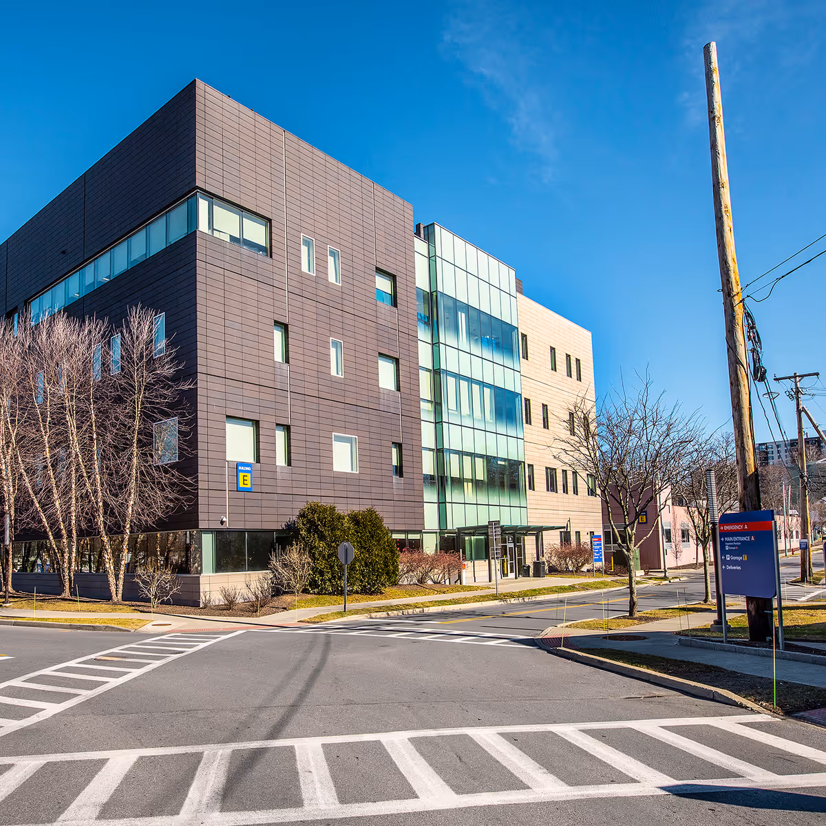 Modern multi-story medical building with glass entrance on a sunny day.
