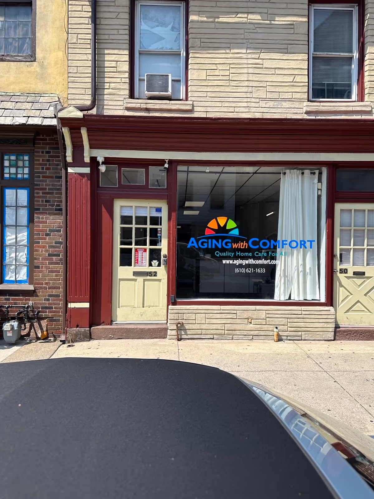 Storefront shows Aging with Comfort logo in a large window.
