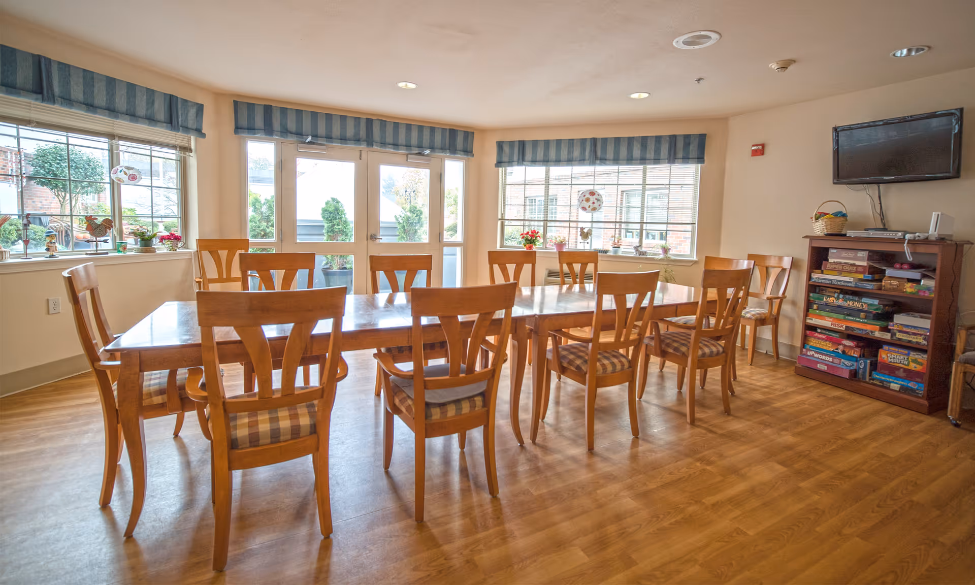 Bright dining room with a long wooden table and chairs near windows.