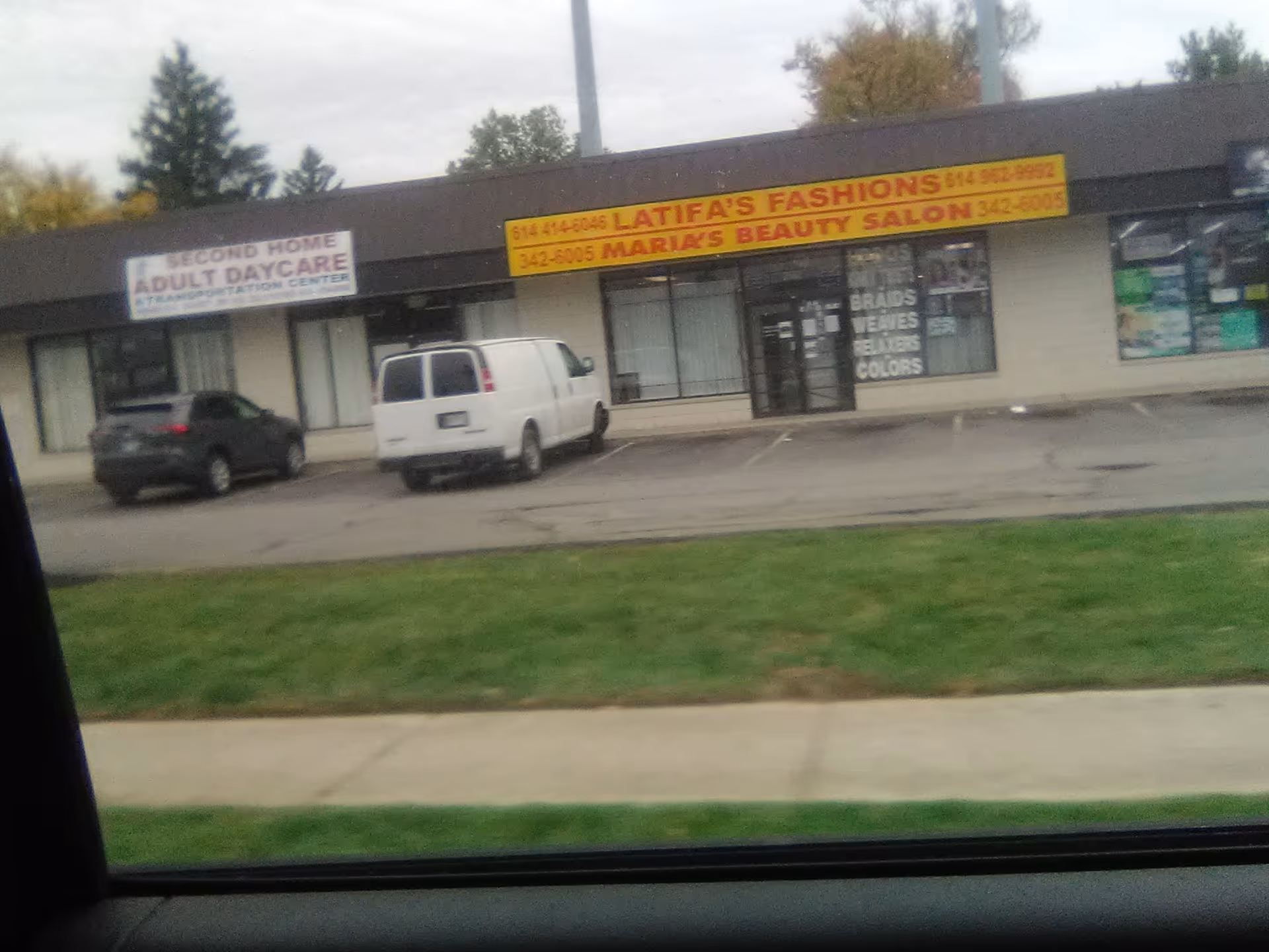 Exterior view of strip mall storefront showing Second Home Adult Day Care entrance and parked cars