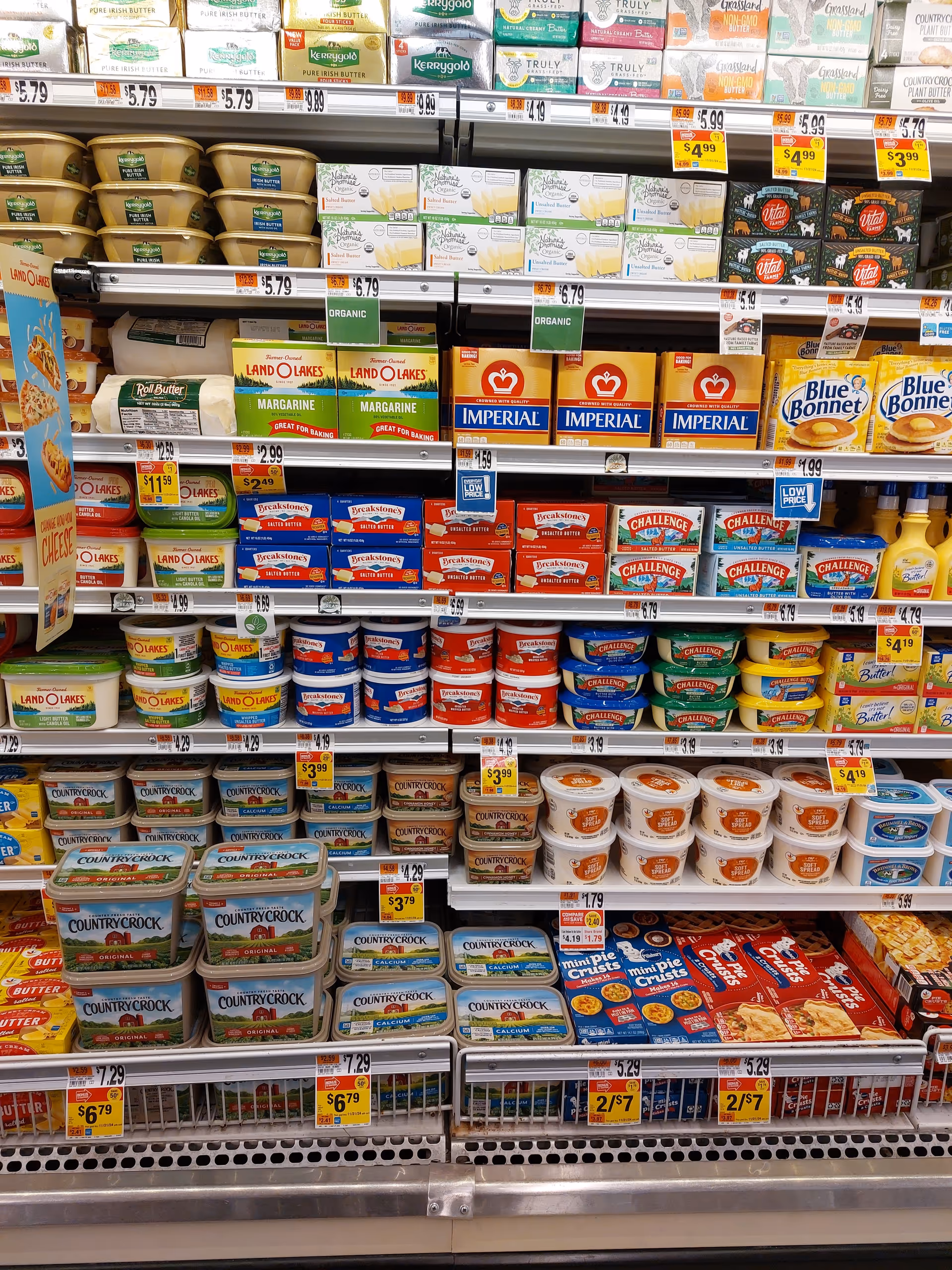 Grocery store shelves stocked with butter, margarine, and dairy products.