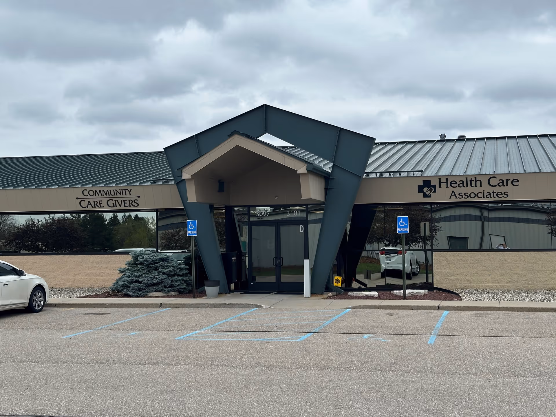 Exterior view of Health Care Associates building entrance with handicap parking signs