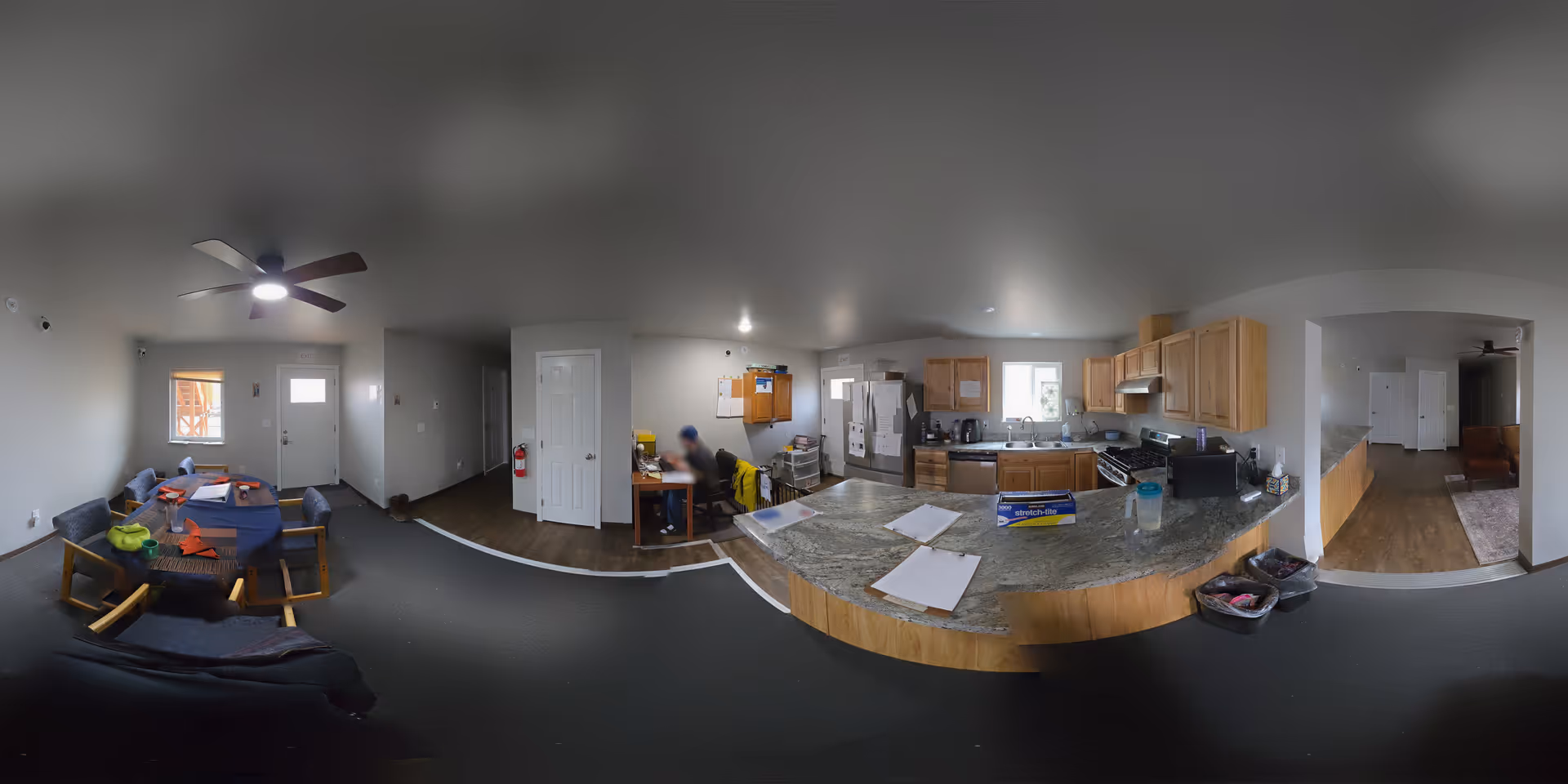 Open-concept senior living interior with a kitchen island, cabinets, appliances, and seating.