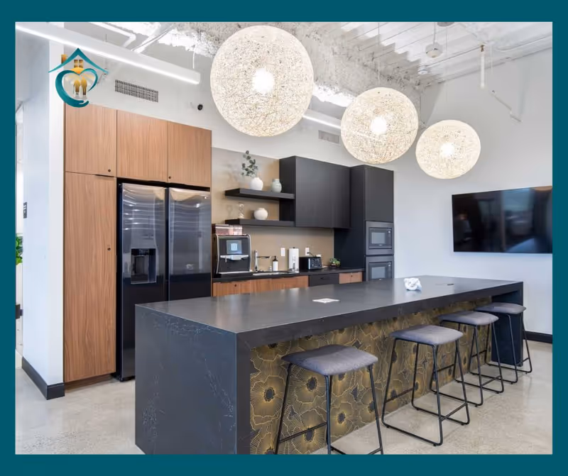 Modern kitchen in a senior living facility with island, bar stools, wood cabinets, and appliances.