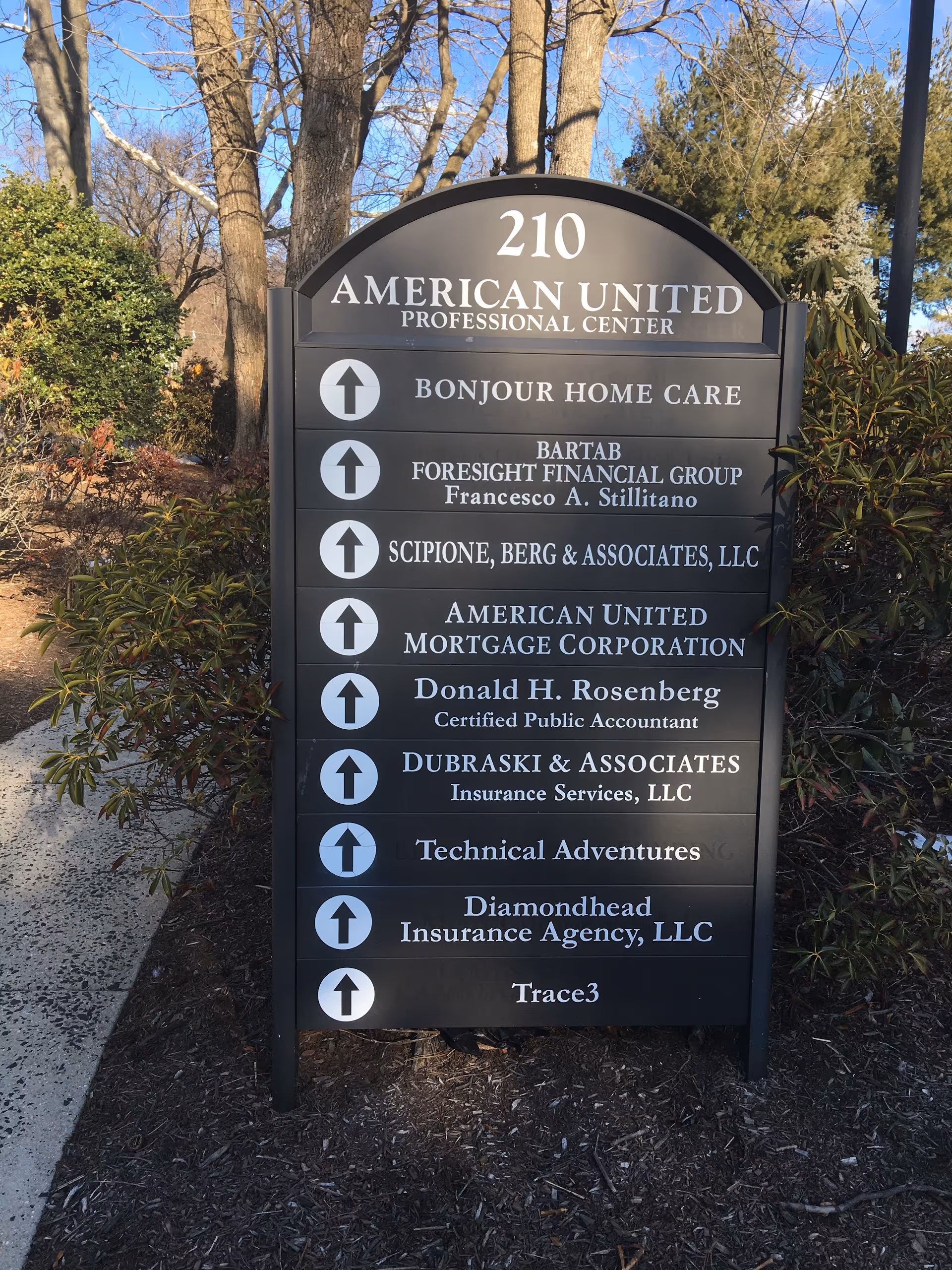Tall outdoor directory sign listing tenants, including Bonjour Home Care.