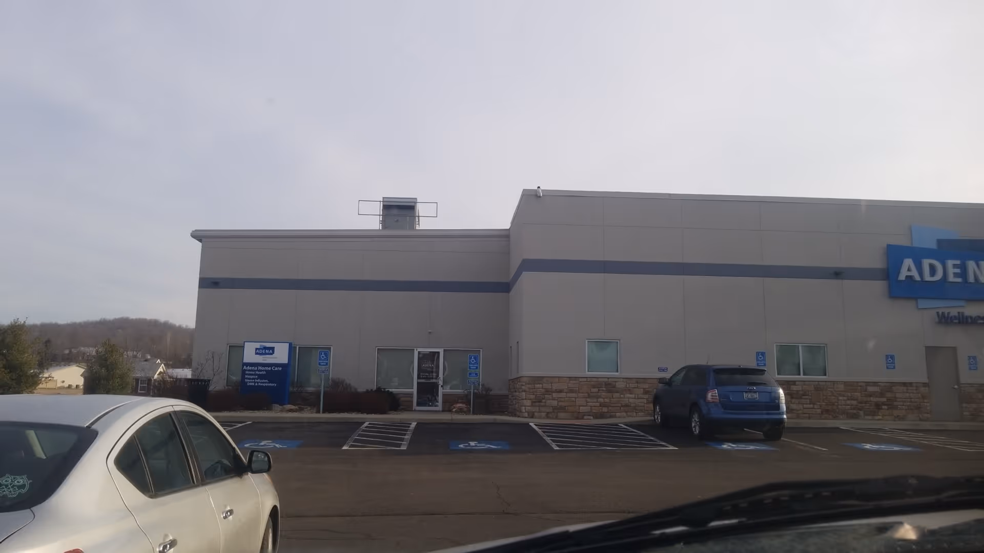 Exterior view of Adena Home Care building with parking spaces in front