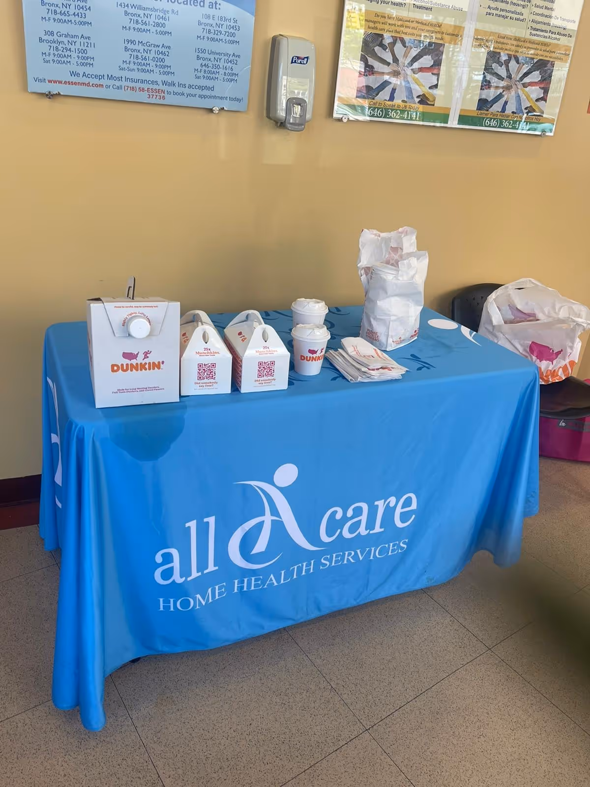 Blue AllCare Home Health Services table with Dunkin' boxes and cups.