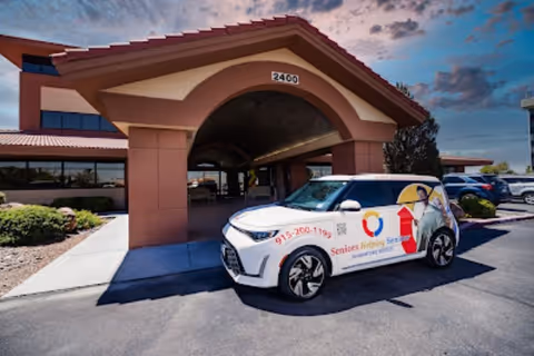 Seniors Helping Seniors El Paso building entrance with a branded promotional car parked outside.