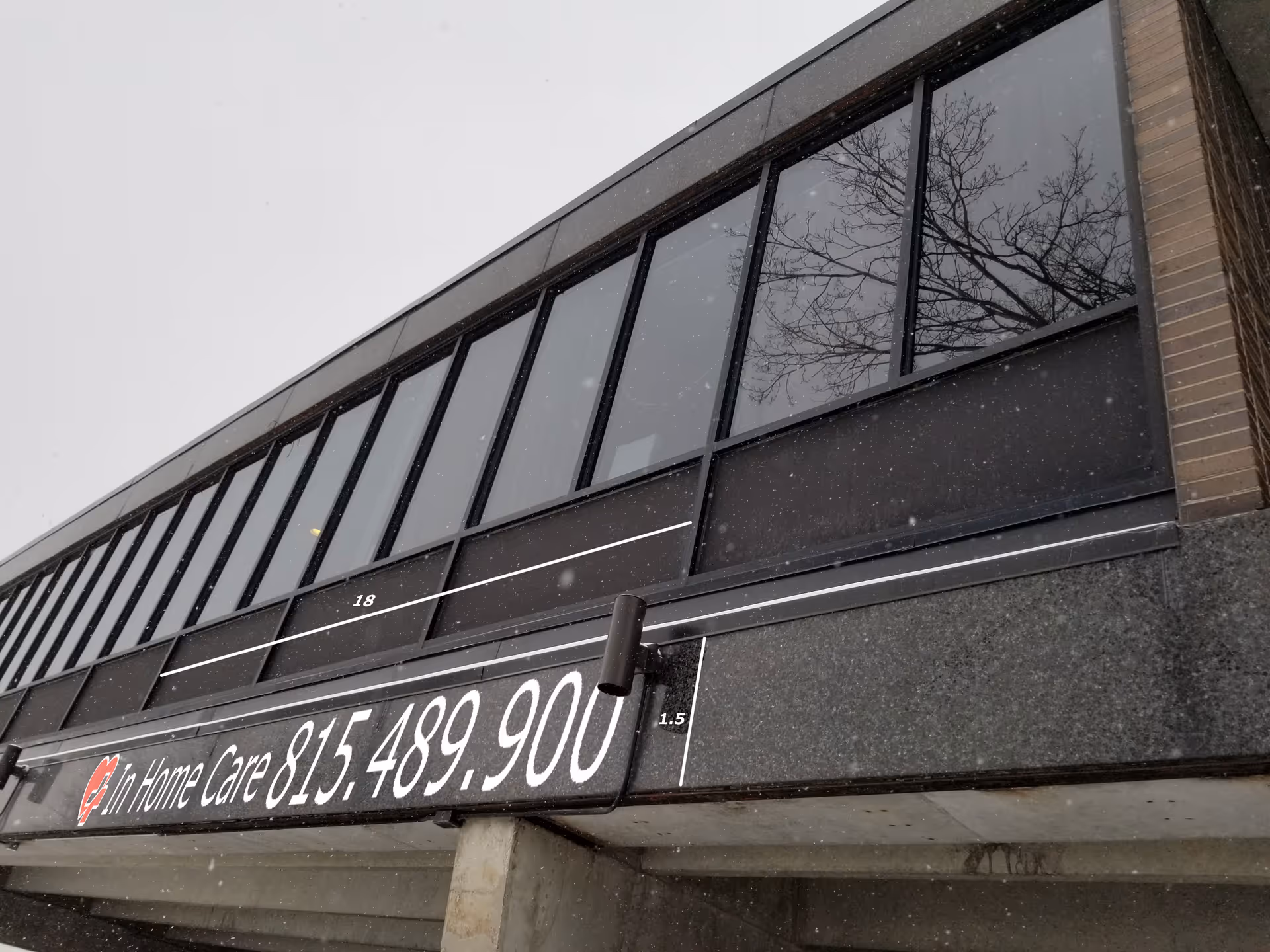 Exterior view of a building with a large In Home Care sign and phone number.