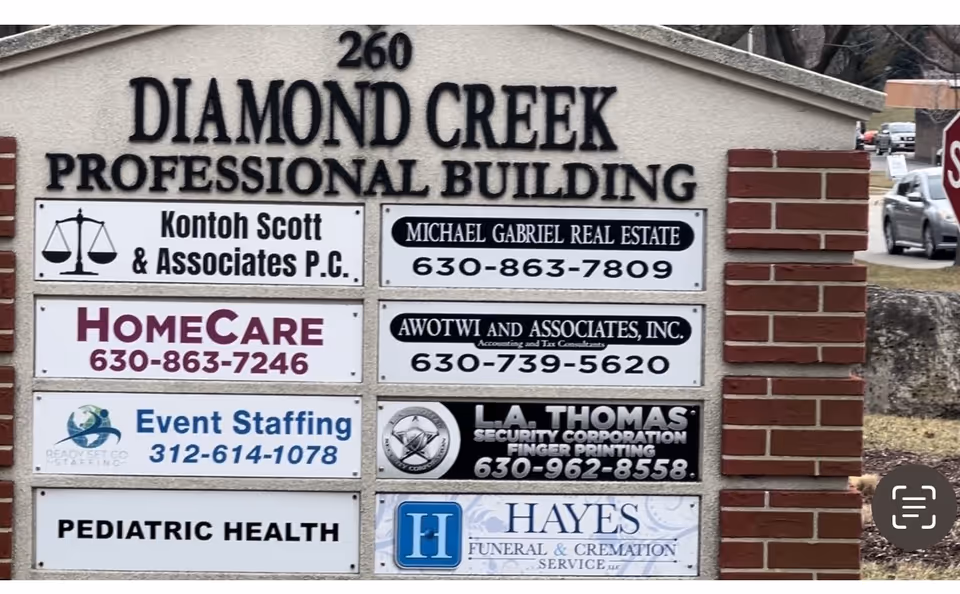 Brick building front with Diamond Creek Professional Building signage and various tenants.