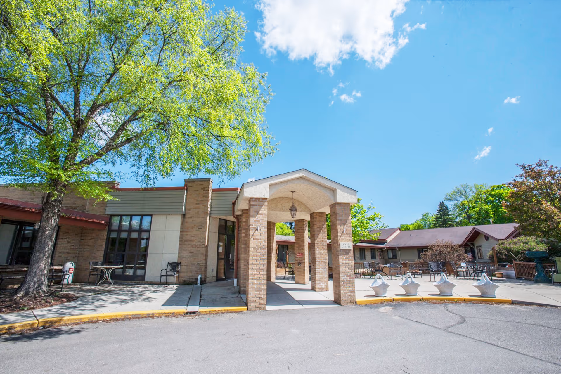 Exterior view of Lake Ridge Care Center of Buffalo with a covered entrance and outdoor seating.