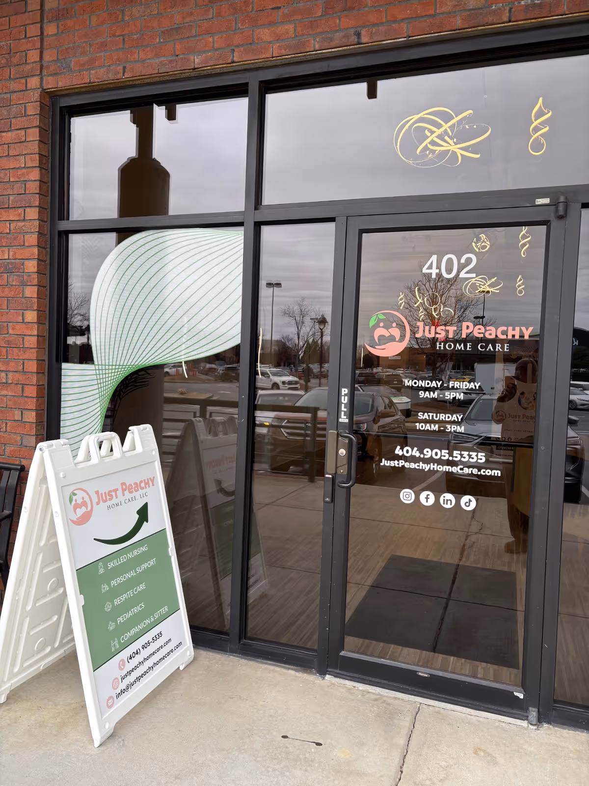 Front entrance of Just Peachy Home Care North with glass door and sidewalk sign.